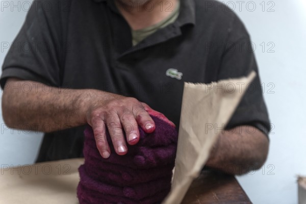 Tunis, Tunisia 22nd May, 2024 A Tunisian Chaouachis works with a vermillion red dye in the making of the traditional Chechia in Souk Ech-Chaouachine, part of the intangible heritage of Tunis Madina, Tunisia