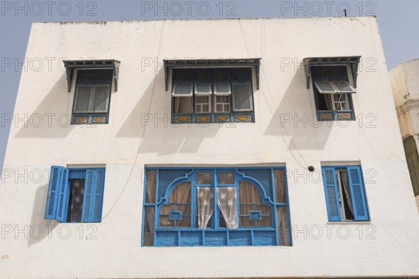 Classic white washed walls and blue painted windows of Tunisian architecture in the UNESCO world heritage site of Tunis Medina, on the Mediterranean coast of North Africa