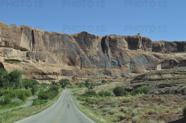 Road leads through an impressive desert landscape with high rock walls, Canyonlands National Park, Island in the Sky, Utah, USA