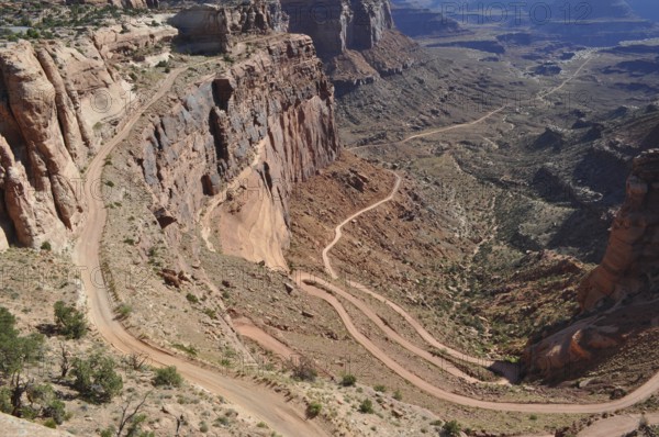 Long gravel road winds through a dramatic desert landscape, Canyonlands National Park, Island in the Sky, Utah, USA