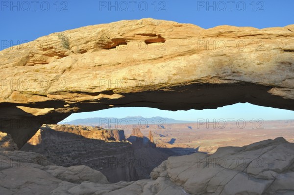 Well-known Mesa Arch rock arch in desert landscape with extensive views of canyon, Canyonlands National Park, Island in the Sky, Utah, USA