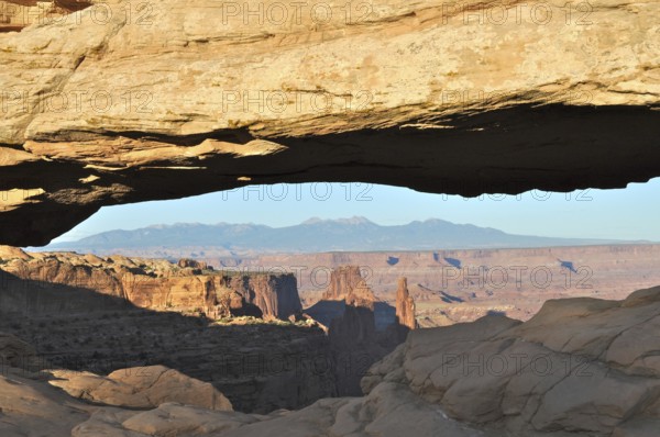 Natural Mesa Arch rock arch with views of mountains and canyon landscape, Canyonlands National Park, Island in the Sky, Utah, USA