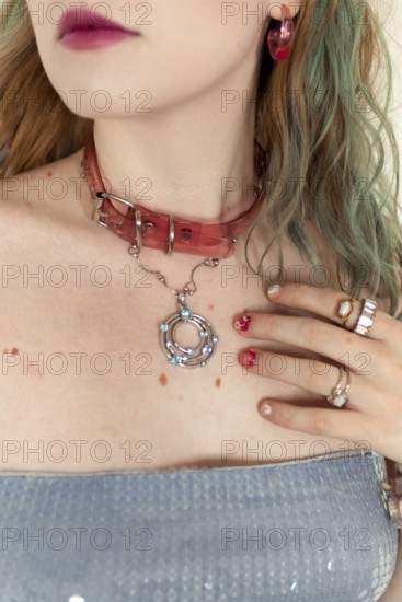 A stylish woman with a pink choker, rings, and earrings Her colorful hair complements the artistic accessories, showcasing an edgy, modern fashion statement Close-up shot