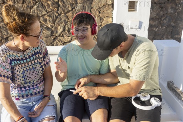 A teenager with Down Syndrome smiling and enjoying music with family The group interacts warmly, symbolizing love, inclusion, and family bonding in a sunny outdoor setting