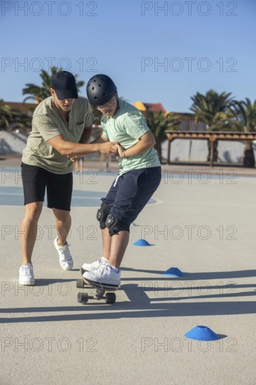 Down syndrome teenager skateboarding outdoors, guided by a supportive family member Emphasizes sports, teamwork, and inclusivity as a family activity