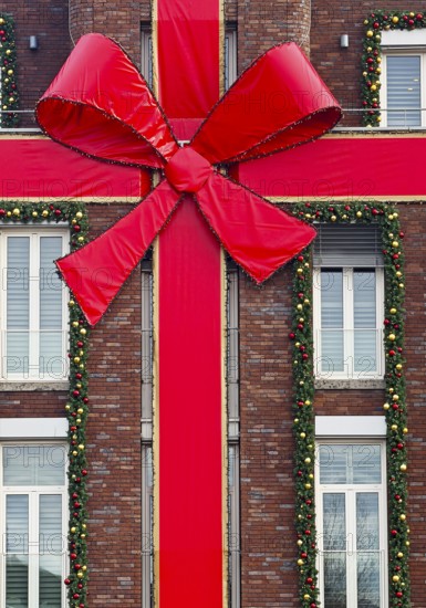 Large red ribbon on a house façade in the run-up to Christmas, Roermond, Limburg province, the Netherlands
