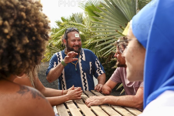 A group of friends enjoys a fun and lively conversation while playing a game outdoors, surrounded by lush greenery, creating a cheerful and relaxed atmosphere