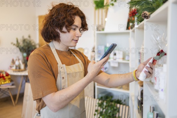 Retail worker using a smartphone to scan a product in a well-lit, contemporary store The scene is vibrant and showcases a modern retail environment with greenery