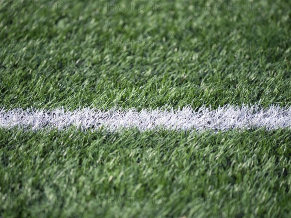 Detailed shot of a soccer field, highlighting the contrast between the vibrant green grass and a crisp white line. Perfect for themes of sports, leisure, and outdoor activities