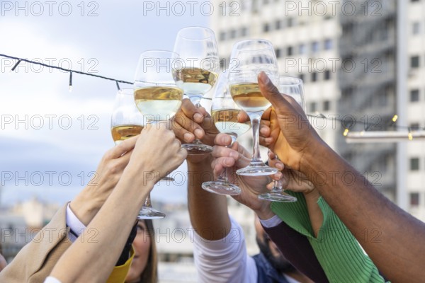 A vibrant group of friends raise their glasses in a rooftop toast, celebrating with joy and laughter against a cityscape backdrop The scene captures a festive, cheerful moment