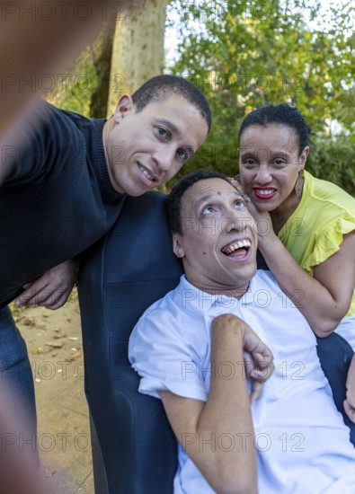 Spanish Cameroonian siblings sharing a joyful moment outdoors. One sibling has cerebral palsy. This touching scene highlights love, diversity, and inclusion