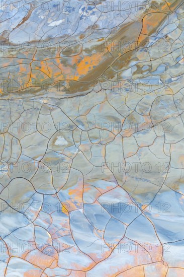 Multicolor cracked mud texture showcasing vibrant patterns and natural hues Abstract art created by nature with intricate lines and diverse color palette, perfect background