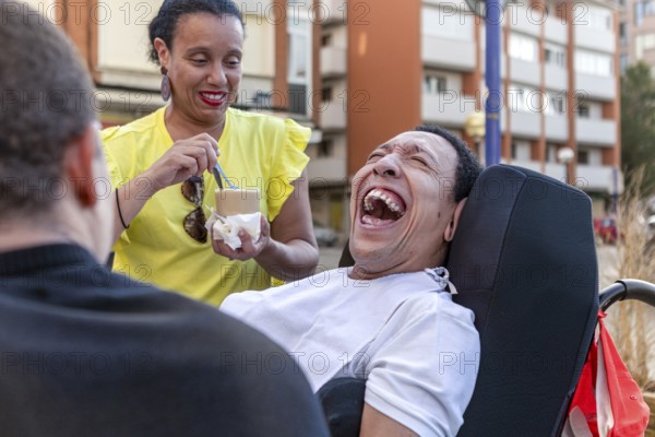 Mixed-race Spanish Cameroonian siblings share a joyful moment outside. One of the siblings, living with cerebral palsy, is at the center of the interaction