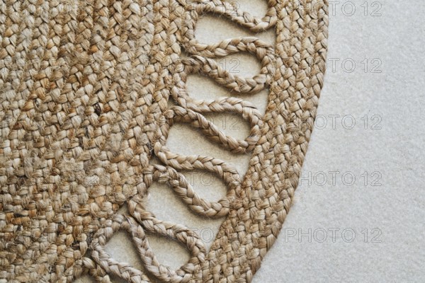 Detailed close-up of a braided jute rug showcasing its intricate woven design. The natural fibers and textures create an elegant and rustic aesthetic ideal for decor themes