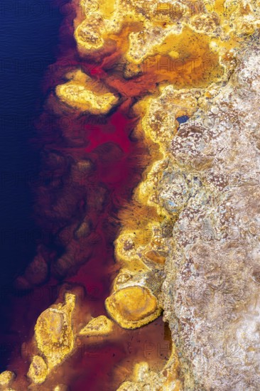 Aerial view of Riotinto River in Huelva, Spain, showcasing vivid red, orange, and blue hues The image captures the unique landscape and mineral-rich waters
