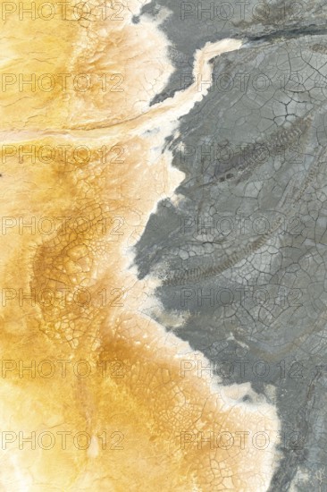 A stunning aerial view of multicolor mud reveals intricate cracks and patterns Earthy tones of gray and yellow create a captivating, natural abstract texture