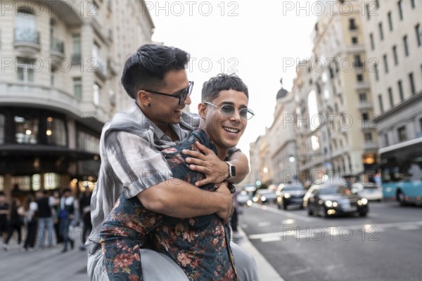 A latin gay couple shares a joyful moment on a bustling street in Madrid, surrounded by beautiful architecture and city life. They express happiness and love in this urban setting
