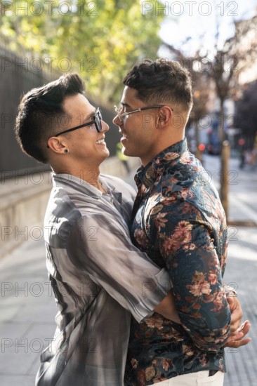 A joyful latin gay couple embraces on a sunny street in Madrid, capturing the essence of happiness and love in a vibrant city environment