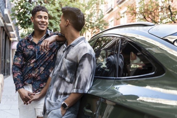 A joyful latin gay couple shares a moment by a car on a charming street in Madrid, showcasing the essence of love and companionship in an urban setting