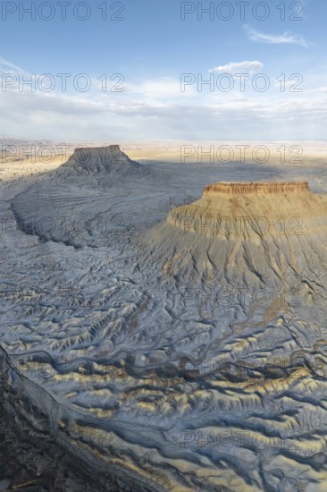 Stunning aerial view of Caineville Mesa, Utah, USA Capturing the majestic landscape, rugged contours, and dramatic shadow play under a vast blue sky