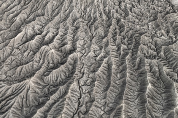 Stunning aerial photograph capturing the intricate, wavy patterns of the eroded land formations at Caineville Mesa near Hanksville, Utah, showcasing nature's artistry in geomorphology