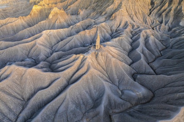 Sunrise lights up the layered hills of Caineville Mesa near Hanskville, Utah, highlighting their intricate textures and patterns