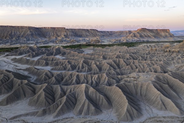 A stunning view of the rugged formations of Caineville Mesa in Utah during sunrise The intricate layers and shadows highlight the natural beauty of this desert landscape