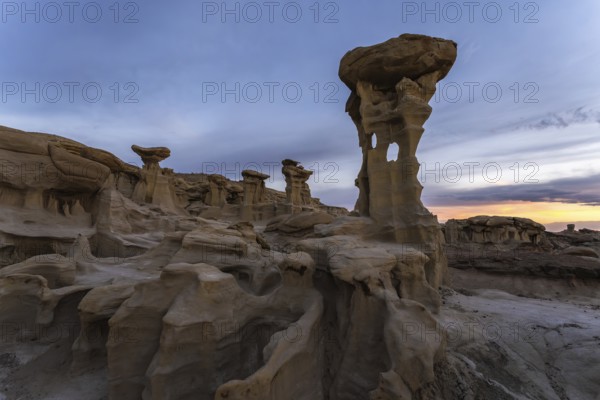 The captivating landscape of Bisti De-Na-Zin Wilderness in New Mexico showcases stunning eroded rock formations against a dramatic sunset sky A unique desert terrain