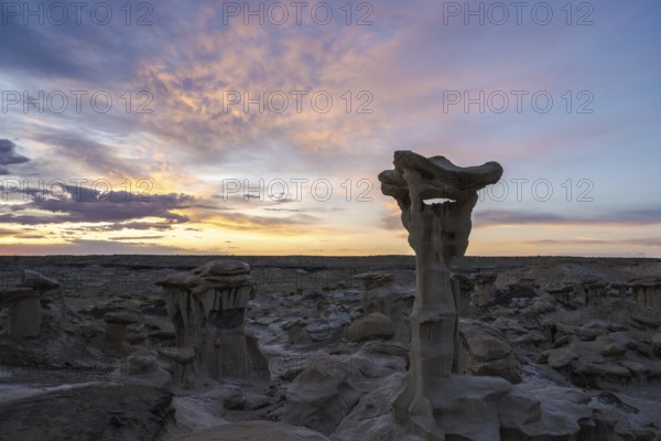 Stunning rock formations under a vibrant sunset sky in Bisti De-Na-Zin Wilderness, New Mexico The unique landscape showcases extraordinary geological features