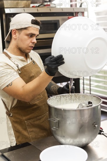A focused baker in an apron and cap prepares dough in a busy Italian bakery kitchen The setting includes professional baking tools, creating an authentic culinary atmosphere