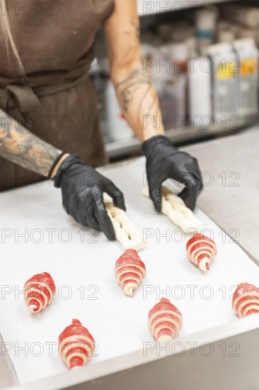 A skilled artisan wearing gloves crafts intricate pastries on a preparation table in an Italian bakery The scene highlights traditional baking techniques and artistry