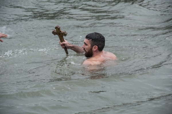 Istanbul, Turkey, January 6th 2017 A man holds a wooden cross after retrieving it from the Golden Horn, celebrations of Epiphany at the Church of Fener Orthodox Patriarchiate in Istanbul, Turkey