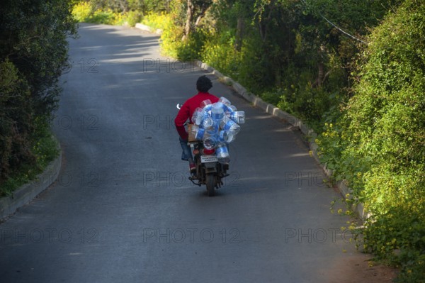 Istanbul, Turkey. 18th April 2016 A man riding a motorcycle with empty plastic water bottles on the Island of Burazada, TheAdalar Islands, Turkey