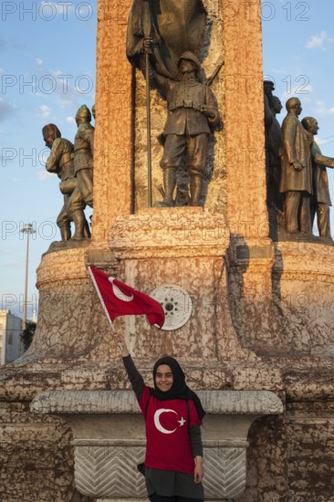 Taksim Square, Istanbul, Turkey. July 18th 2016 A proud Turkish girl with a Turkish flag poses in front the Ataturk memorial in Taksim square during celebrations of a failed coup attempt