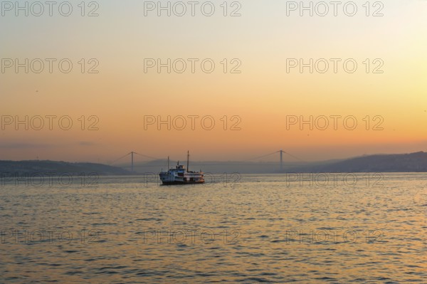 Istanbul, Turkey. Beautiful misty sunrise over the Bosporus, with the European and Asian shores as a ferry crosses towards Karakoy and Galataport
