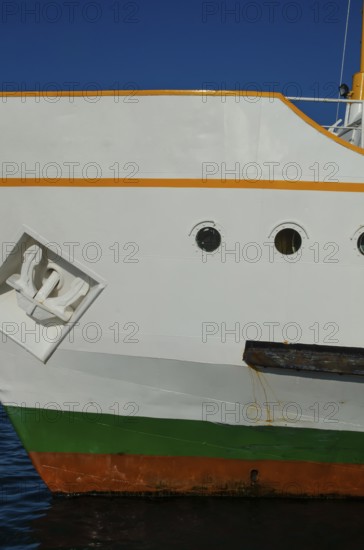 The bright colours of a ship's hull against a dark blue sky