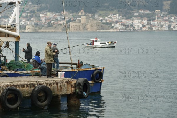 Canakkale, Turkey. 18th February 2022 Turkish fishermen on the pier overlooking the Dardanelles straight and Gallipoli Peninsula in Canakkale, north western Turkey