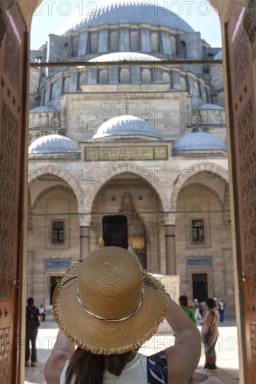 A foreign tourist enters the Suleymaniye Camii, an Ottoman imperial Mosque over looking Istanbul built by famous historical architect, Mimar Sinan