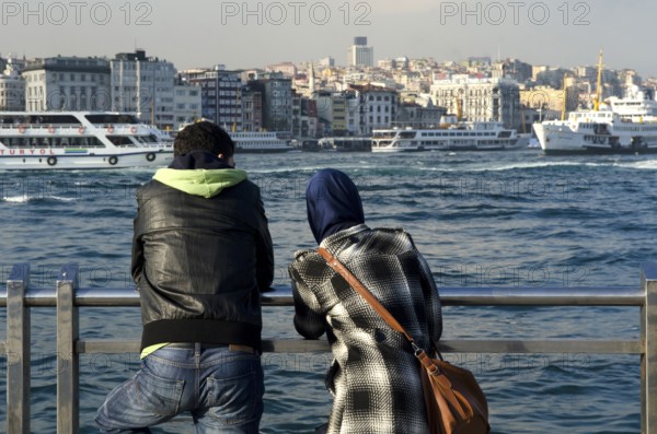 Istanbul, Turkey. April 11th 2012 Young Turkish couple look out at the Bosporus, Istanbul, Turkey