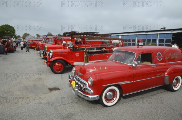 Veteran fire trucks in a row, closest to the fire chief's car, Chevrolet built in 1952 at fire truck rally in Ystad, Skåne County, Sweden, Scandinavia