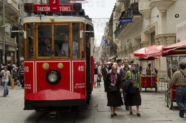 May 21st 2012. Istanbul, Turkey. Old Turkish women passing a traditional tram along Istiklal Street Istanbul Turkey
