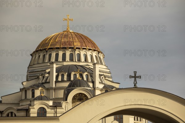 The image showcases a stunning golden dome of an orthodox church against a cloudy sky in Georgia Prominent crosses and intricate architecture highlight the building's grandeur