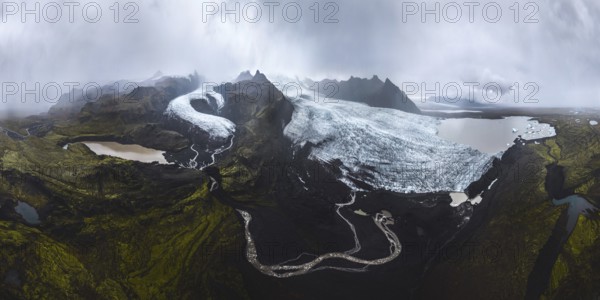 A breathtaking panoramic view of Vatnajokull glaciers in Iceland's Highlands Features vast ice expanses, rugged mountains, and serene lakes under a moody sky