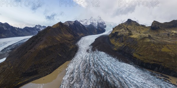 Captivating panoramic view of the majestic Vatnajokull National Park in Iceland, showcasing a dramatic blend of glacial and mountainous landscapes under a vivid sky
