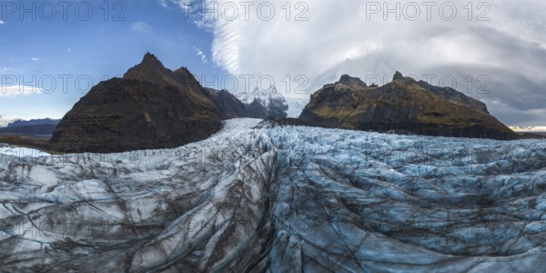 Stunning panoramic view of Vatnajokull National Park's glacier, capturing the rugged beauty of Iceland's vast ice formations and dramatic mountain backdrop