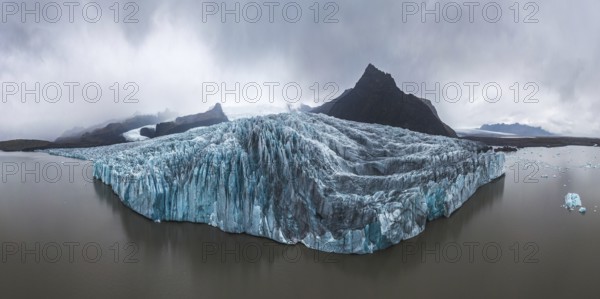 Panoramic view of the stunning Vatnajokull Glacier in Iceland's Vatnajokull National Park Captures the rugged beauty of the glacier amid rocky landscapes and cloudy skies