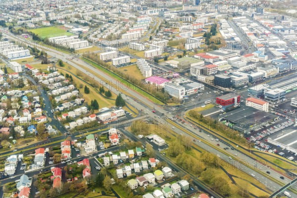 Aerial image of Reykjavik, Iceland, displaying a detailed urban layout with dense housing and structured road systems, highlighting the unique city planning amidst natural landscapes