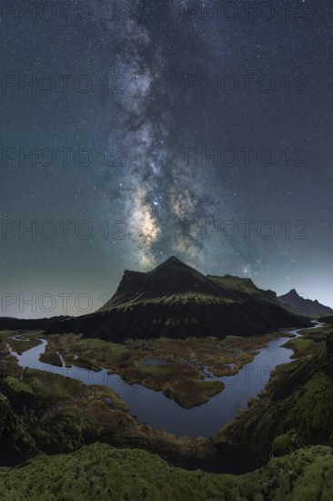 Breathtaking night sky over Iceland, capturing the Milky Way above a serene river and rugged mountains A stunning blend of natural beauty and celestial wonder