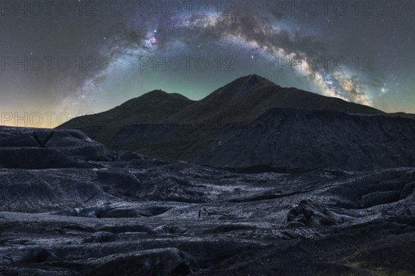 Captivating Icelandic terrain under a stunning starry sky The Milky Way arcs gracefully above, illuminating the rugged landscape with an ethereal glow