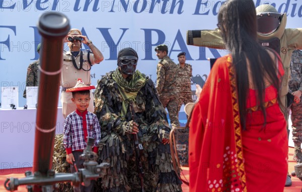 A child poses for a photograph beside a CRPF commando in full camouflage gear during a public interaction segment at the 87th Raising Day celebrations, on February 19, 2026 in Guwahati, India